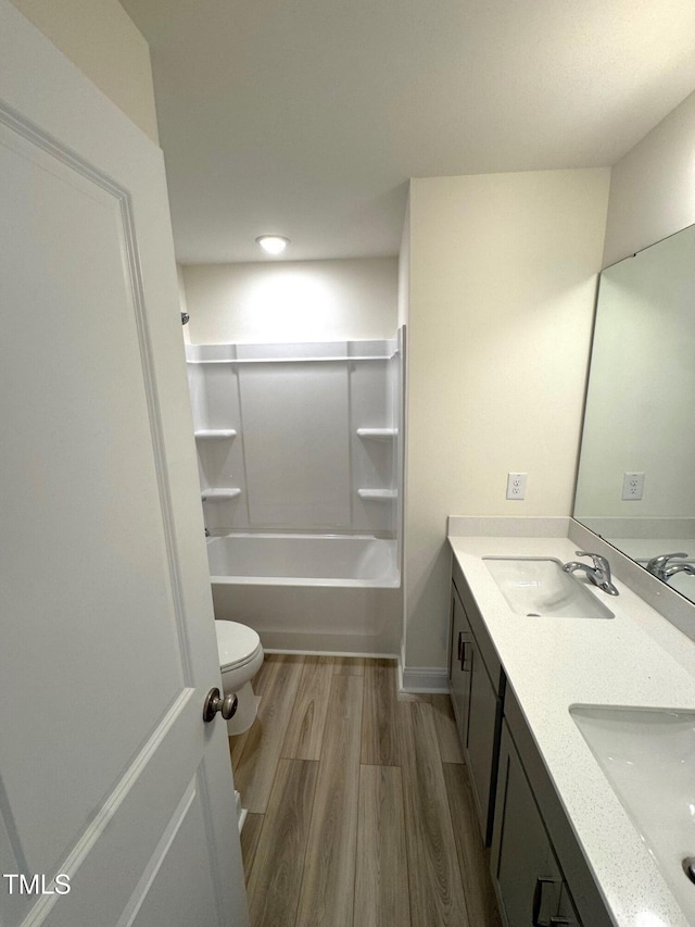 full bathroom featuring hardwood / wood-style floors, vanity,  shower combination, and toilet