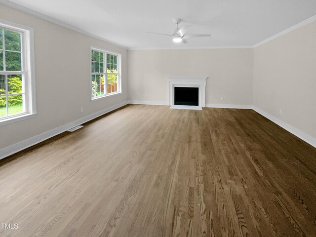 unfurnished living room featuring light wood-type flooring, ceiling fan, a healthy amount of sunlight, and crown molding