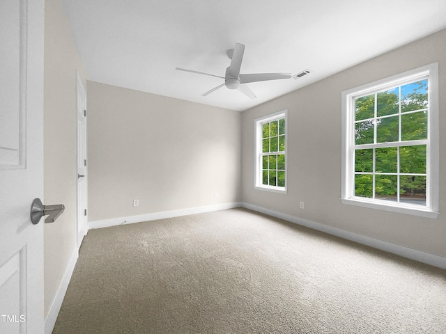 carpeted empty room with a wealth of natural light and ceiling fan