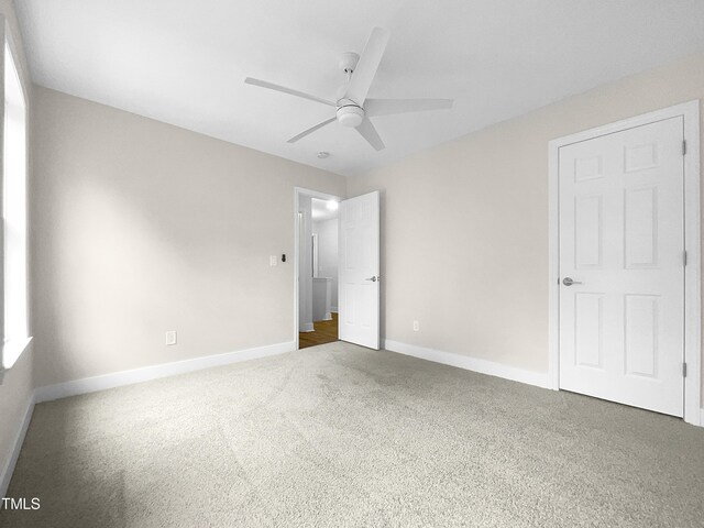 unfurnished bedroom featuring ceiling fan and dark carpet