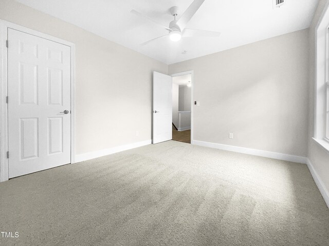 unfurnished room featuring ceiling fan and carpet