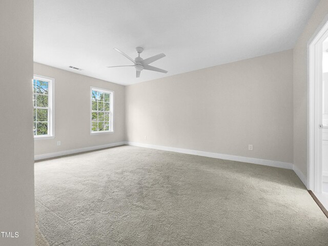 carpeted spare room with ceiling fan