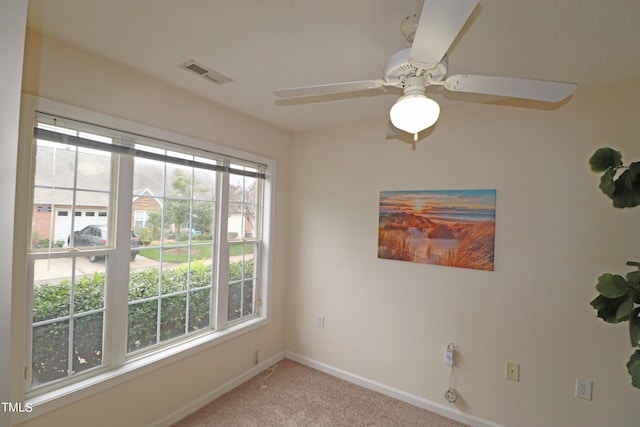 empty room with plenty of natural light, ceiling fan, and light carpet