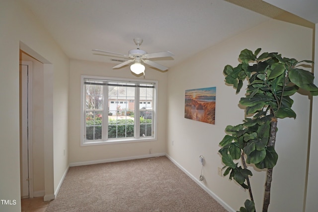 empty room with ceiling fan, lofted ceiling, and light carpet