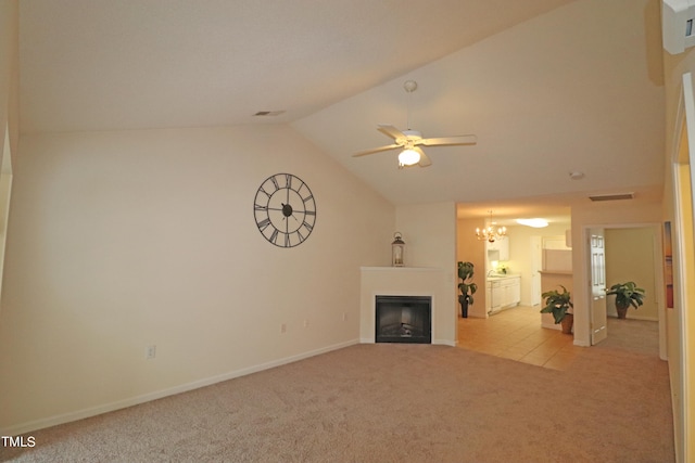 unfurnished living room with ceiling fan with notable chandelier, light carpet, and vaulted ceiling