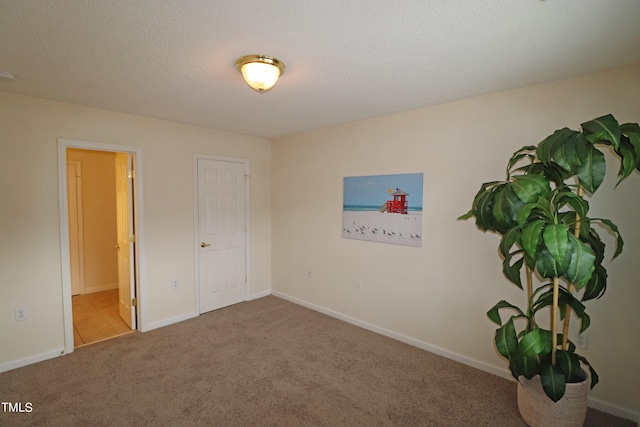 spare room with carpet and a textured ceiling