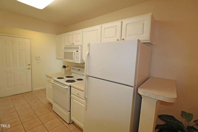 kitchen featuring light tile patterned flooring, white appliances, a textured ceiling, and white cabinetry