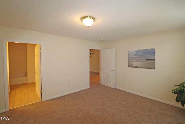 empty room featuring light carpet and a textured ceiling