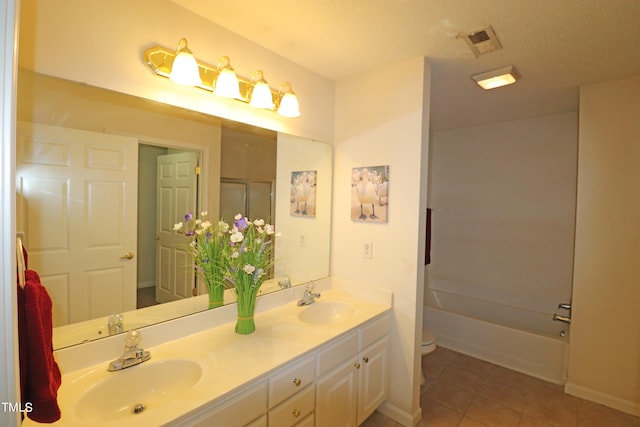 bathroom with tile patterned floors, vanity, a textured ceiling, and toilet