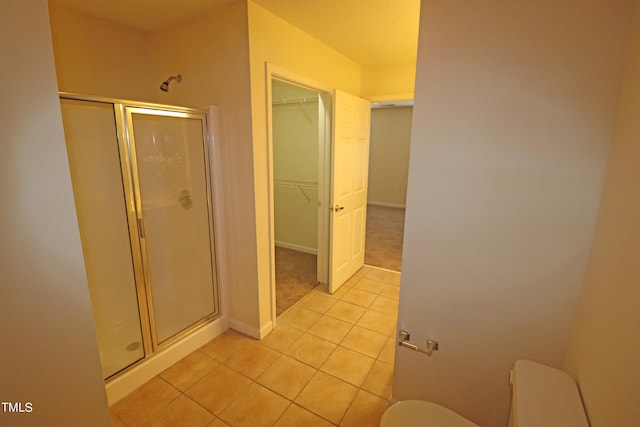 bathroom with tile patterned floors and a shower with door