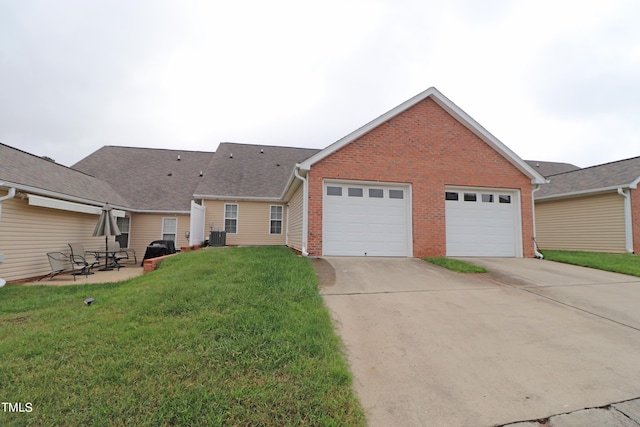 view of front of property featuring a front yard, a garage, and central AC unit