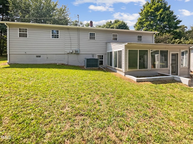 rear view of house featuring a lawn, cooling unit, and a sunroom