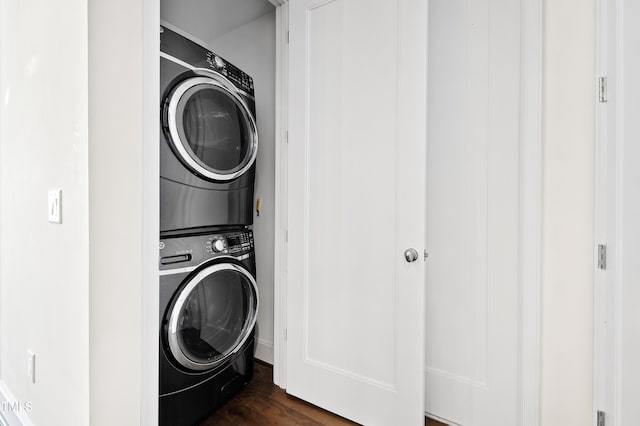 washroom featuring stacked washer / drying machine and dark hardwood / wood-style floors