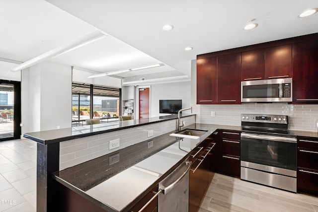 kitchen featuring tasteful backsplash, sink, stainless steel appliances, and plenty of natural light