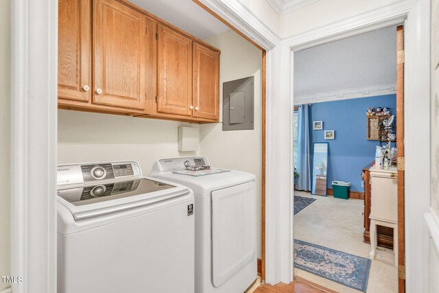 laundry room featuring cabinets, independent washer and dryer, crown molding, and electric panel