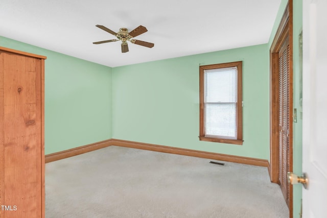 unfurnished bedroom with light carpet, a closet, and ceiling fan