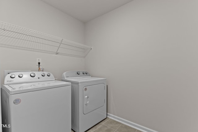 clothes washing area featuring washing machine and dryer and light tile patterned floors