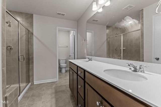 bathroom with toilet, an enclosed shower, vanity, and tile patterned flooring