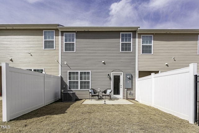 rear view of property with central AC, a patio, and a fenced backyard