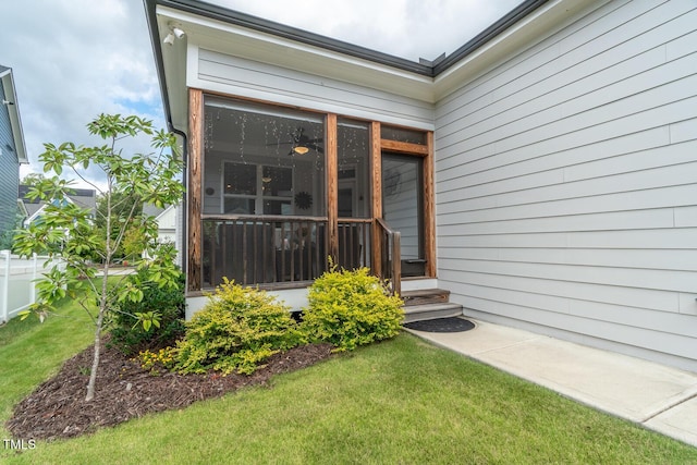 view of exterior entry with a yard