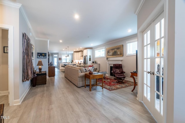 living room with light hardwood / wood-style floors, crown molding, and french doors