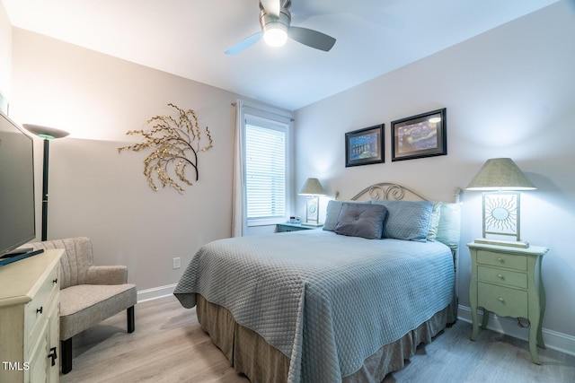 bedroom featuring light wood finished floors, a ceiling fan, and baseboards