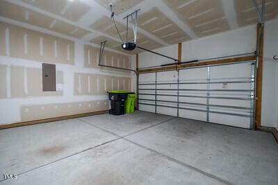 garage featuring electric panel and a garage door opener