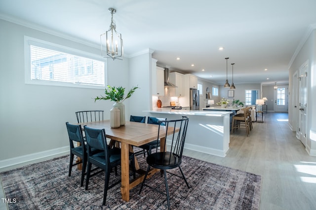 dining area featuring ornamental molding, a chandelier, baseboards, and wood finished floors