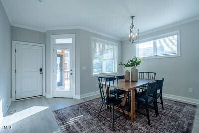 dining area featuring baseboards, crown molding, and wood finished floors