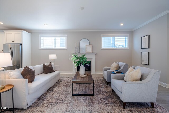 living area with a wealth of natural light, a fireplace, crown molding, and baseboards