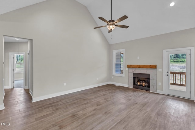 unfurnished living room with light hardwood / wood-style flooring, a wealth of natural light, ceiling fan, and a fireplace