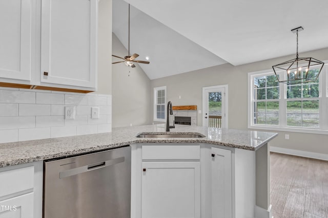 kitchen featuring white cabinets, sink, dishwasher, ceiling fan with notable chandelier, and vaulted ceiling