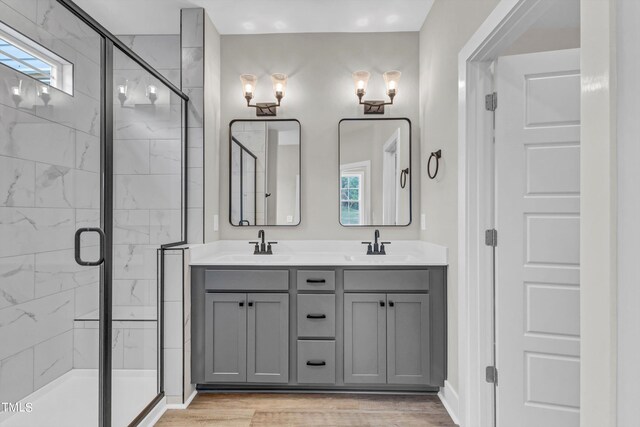 bathroom with vanity, a shower with shower door, and hardwood / wood-style floors