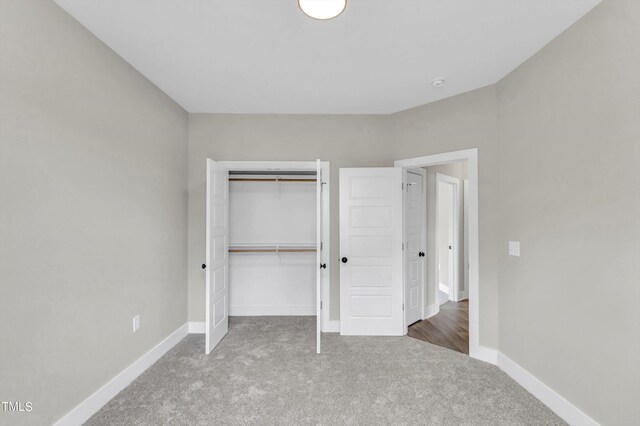 unfurnished bedroom featuring carpet flooring and a closet