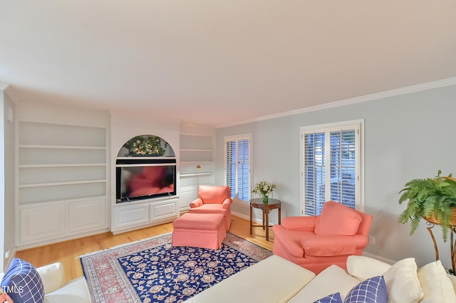 living room with ornamental molding, built in shelves, and light wood finished floors