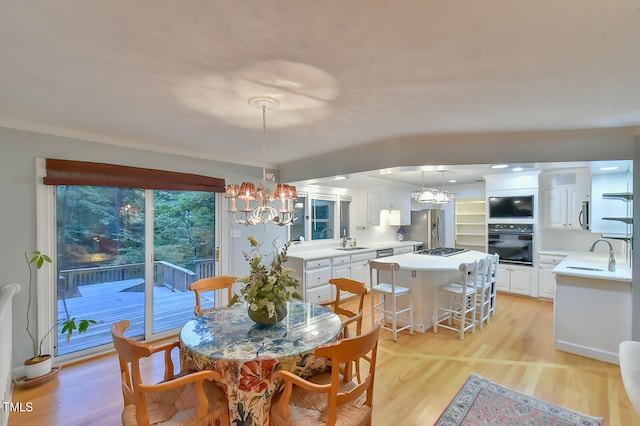 dining area with light wood-style flooring and a notable chandelier