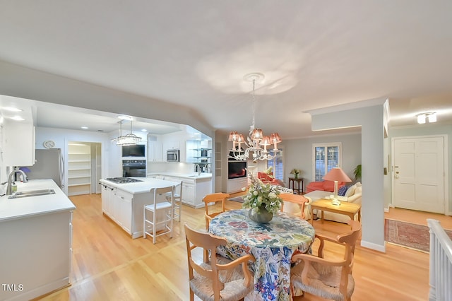 dining room with baseboards, light wood-style flooring, and an inviting chandelier