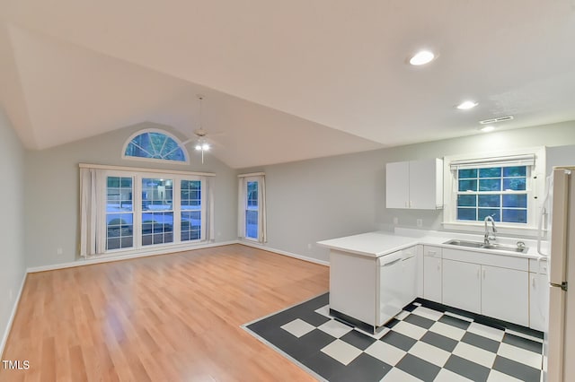 kitchen with white appliances, a sink, white cabinets, open floor plan, and light countertops