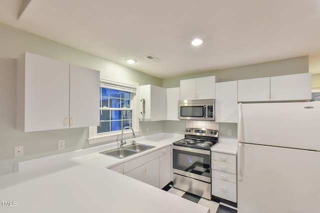 kitchen featuring stainless steel appliances, a sink, visible vents, white cabinets, and light countertops