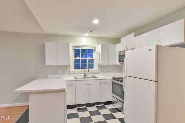 kitchen featuring stainless steel appliances, a sink, light countertops, and white cabinets