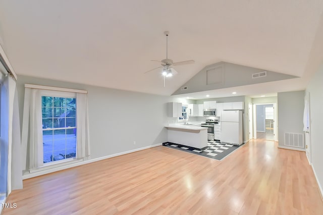 unfurnished living room featuring light wood-style flooring, a sink, and visible vents