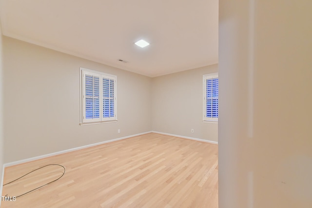 unfurnished room with light wood-style flooring and baseboards