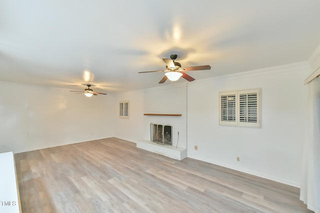 unfurnished living room with ornamental molding, a fireplace, visible vents, and light wood-style floors