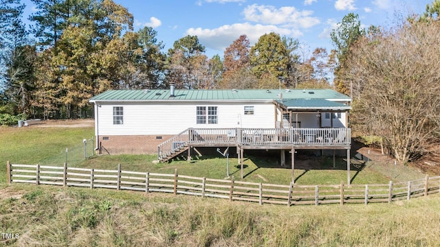 rear view of property featuring a yard, a wooden deck, and a rural view