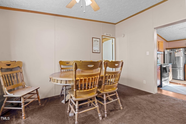 carpeted dining area with ornamental molding, ceiling fan, and a textured ceiling