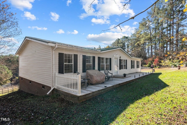 back of property featuring a deck and a yard