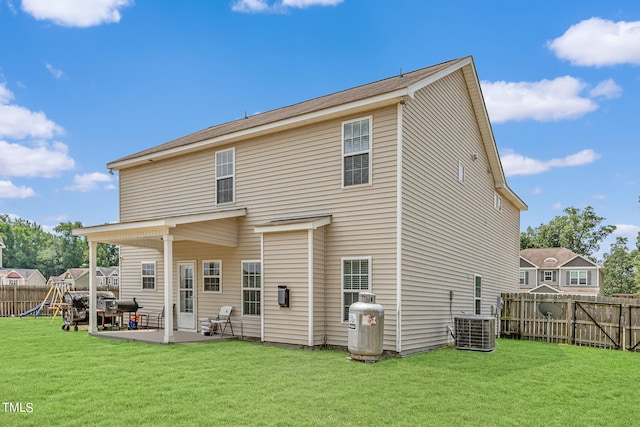 rear view of property with a lawn, a patio area, and central AC