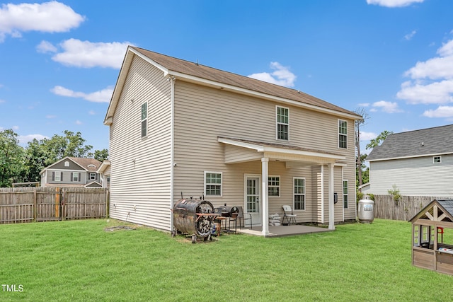 rear view of house featuring a yard and a patio area