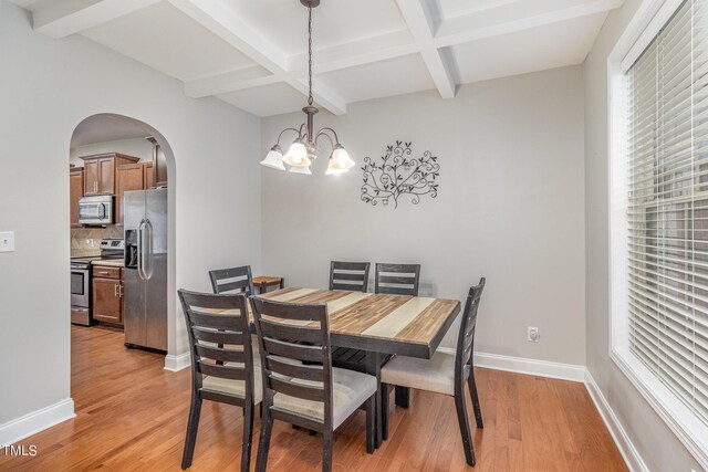 dining area featuring coffered ceiling, beam ceiling, a chandelier, and light hardwood / wood-style flooring