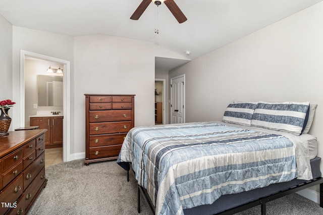 bedroom featuring vaulted ceiling, ceiling fan, light colored carpet, and ensuite bathroom